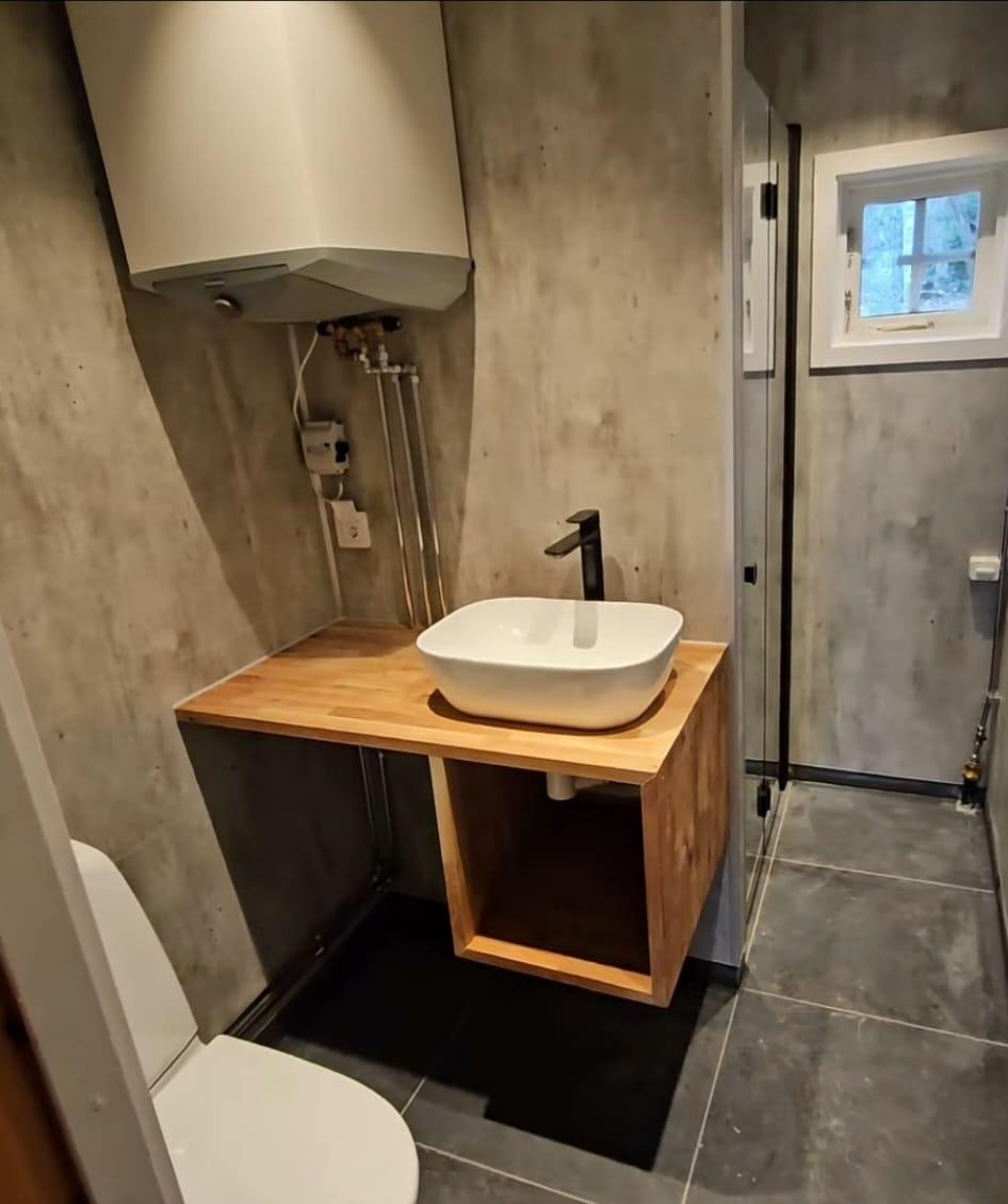 Gerenoveerde badkamer met betonlook wanden, eiken plank en opzetwastafel