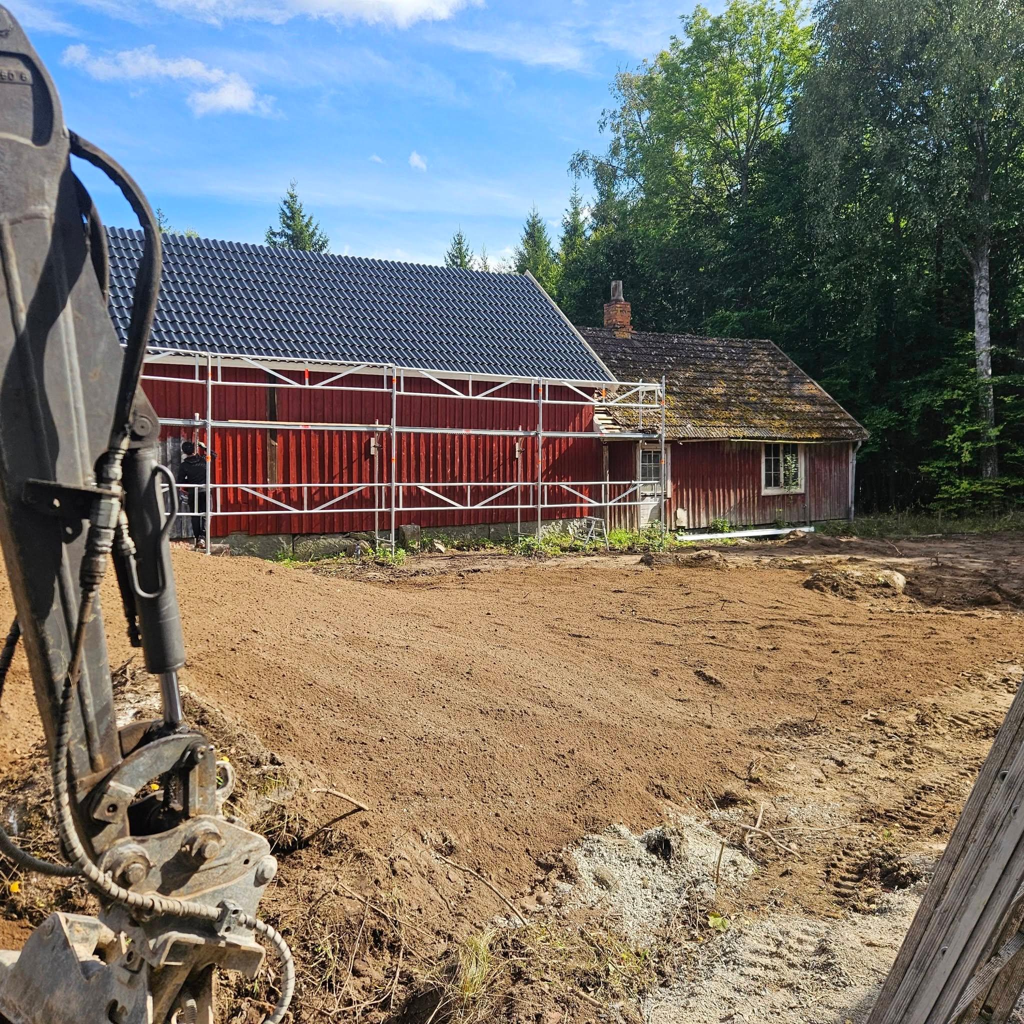 Ladan med nytt svart tak och ny röd panel, ställning längs fasaden