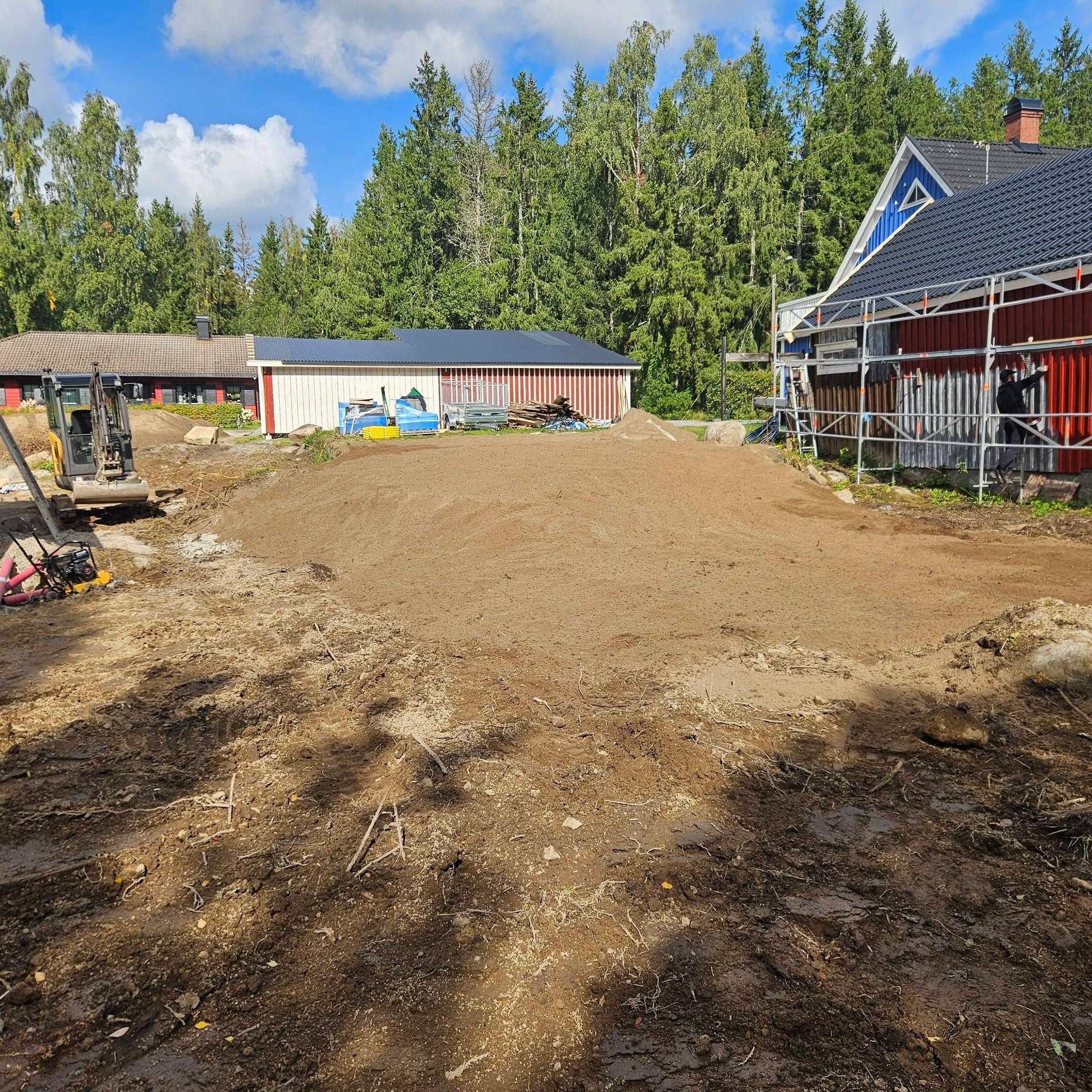 Planerad och packad gårdsplan mellan byggnaderna efter markarbetet