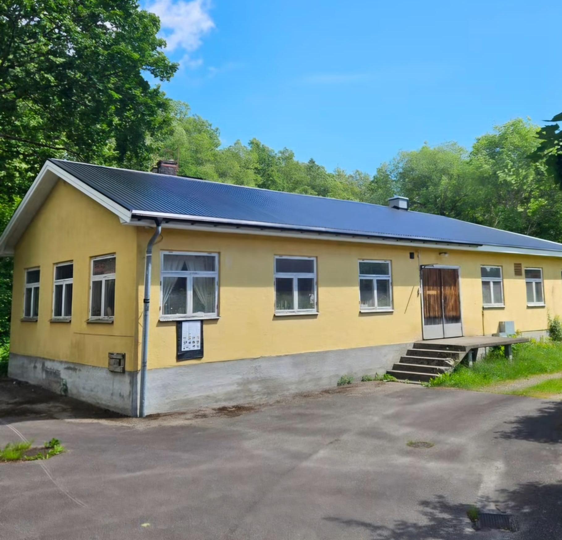 Yellow rendered house with new black metal roof