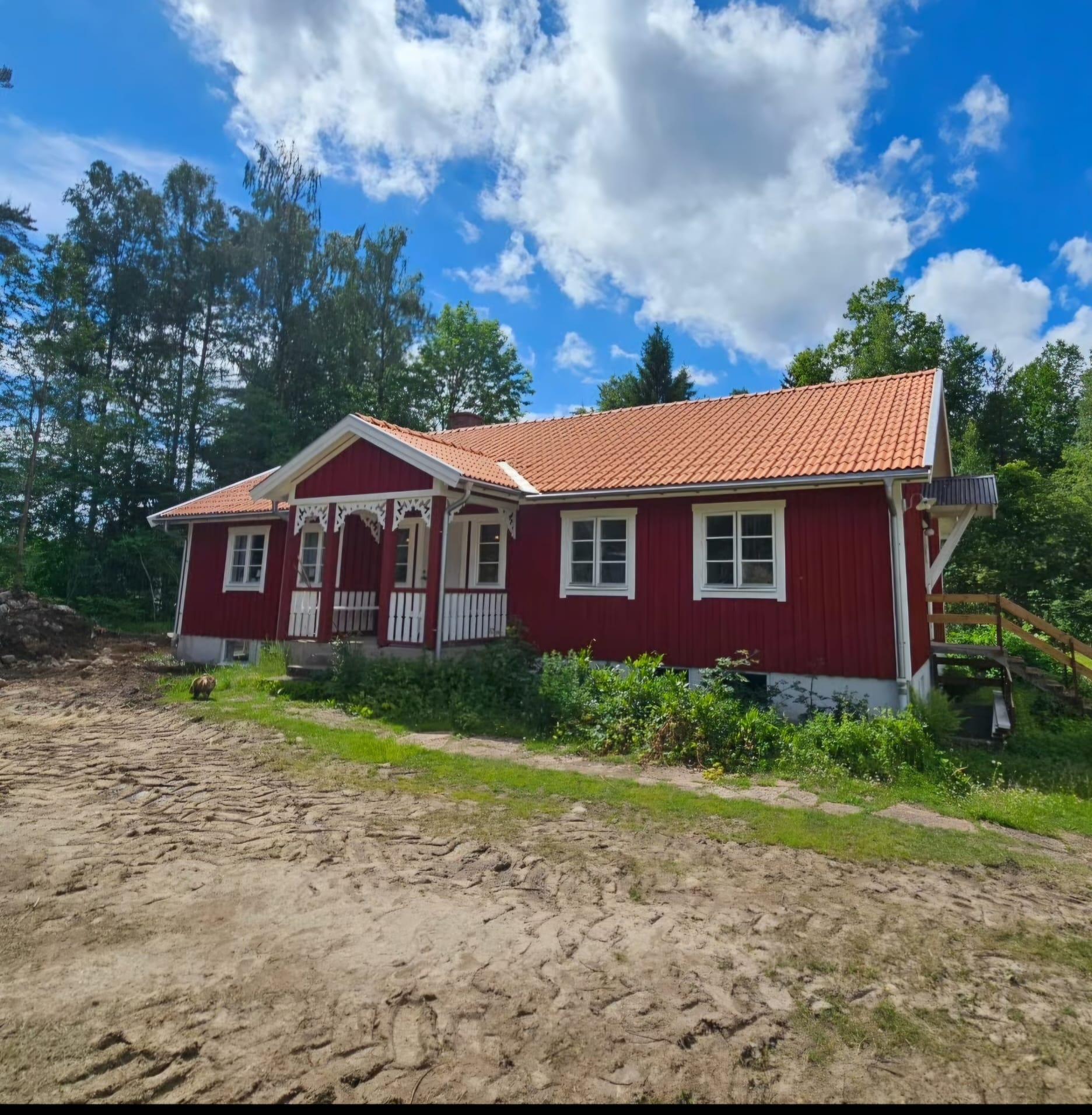 Red timber house with white corners, new tiled roof and carved veranda