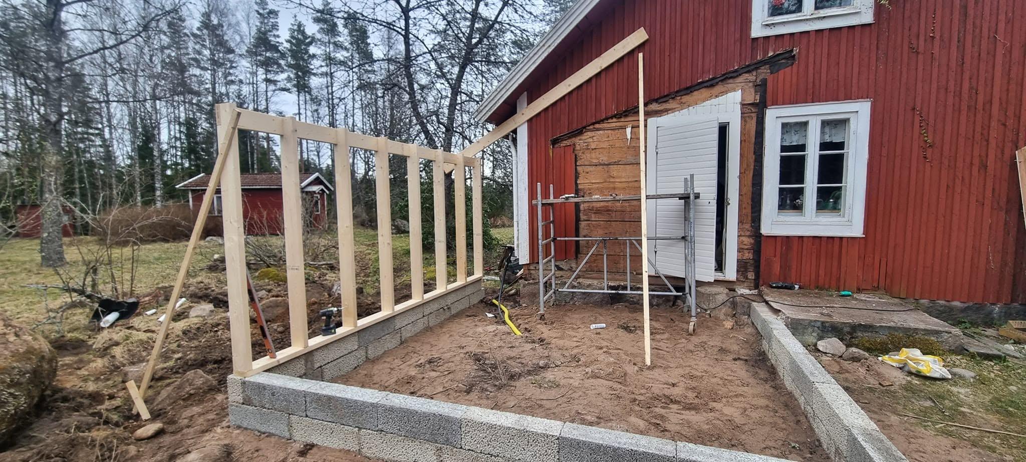 Regelstomme till tillbyggnad på blockgrund intill rött hus